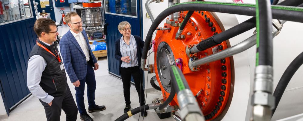 Anna Söderholm, Daniel Kajhager och Karl Lindblom i en av de nyinredda textboxarna, där en stor Hägglunds CBM-motor för tillfället är monterad för tester. Foto: Hägglunds