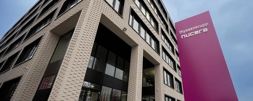 Thyssenkrupp Nuceras huvudkontor i Dortmund. Thyssenkrupp Nucera är ett teknikföretag specialiserat på elektrolysörer – anläggningar som använder elektricitet för att spjälka vatten till vätgas och syre. Företaget är en del av den tyska industrikoncernen Thyssenkrupp och har sitt huvudkontor i Dortmund. Nucera tillverkar framför allt alkaliska elektrolysörer i stor skala och arbetar även med att utveckla ny teknik som fastoxid-elektrolysörer. Deras lösningar används i rena vätgasprojekt världen över, inklusive Neom i Saudiarabien och det svenska projektet Stegra. Målet är att möjliggöra produktion av vätgas med låg klimatpåverkan som kan ersätta fossila bränslen inom industri och energiförsörjning. Foto: Thyssenkrupp Nucera