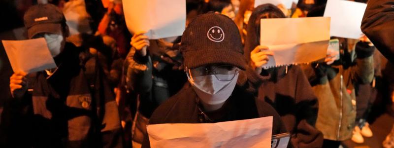 Ng Han Guan/AP/TT: Demonstranter håller upp vita pappersark, som ska symbolisera censur, under en demonstration i Peking på söndagen.