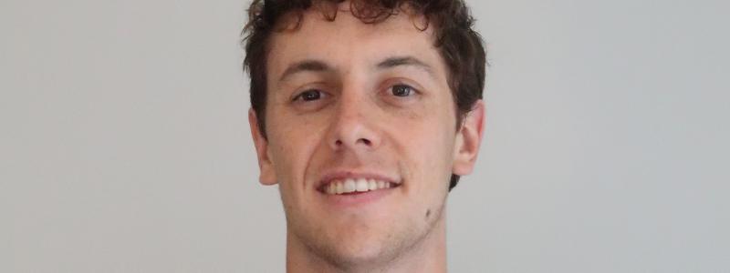 Bilden ovan: Charles Auguste från Mälardalens universitet – vinnare av Automation Student 2023 samt robothanden som lyfter upp en tygbit. 
