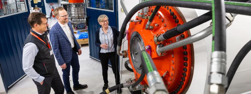 Anna Söderholm, Daniel Kajhager och Karl Lindblom i en av de nyinredda textboxarna, där en stor Hägglunds CBM-motor för tillfället är monterad för tester. Foto: Hägglunds