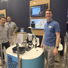 Dom Rugg-Gunn (till höger), robotikingenjör på Cambridge Consultants, vid bolagets monter på MWC 2026. Den humanoida roboten mellan teammedlemmarna är den som under mässan demonstrerade hur AI kan tolka mänskliga gester och plocka upp objekt. Foto: Nicholas Christiansen.