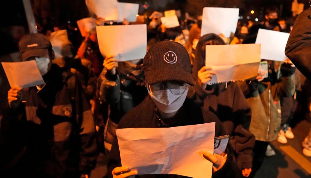 Ng Han Guan/AP/TT: Demonstranter håller upp vita pappersark, som ska symbolisera censur, under en demonstration i Peking på söndagen.