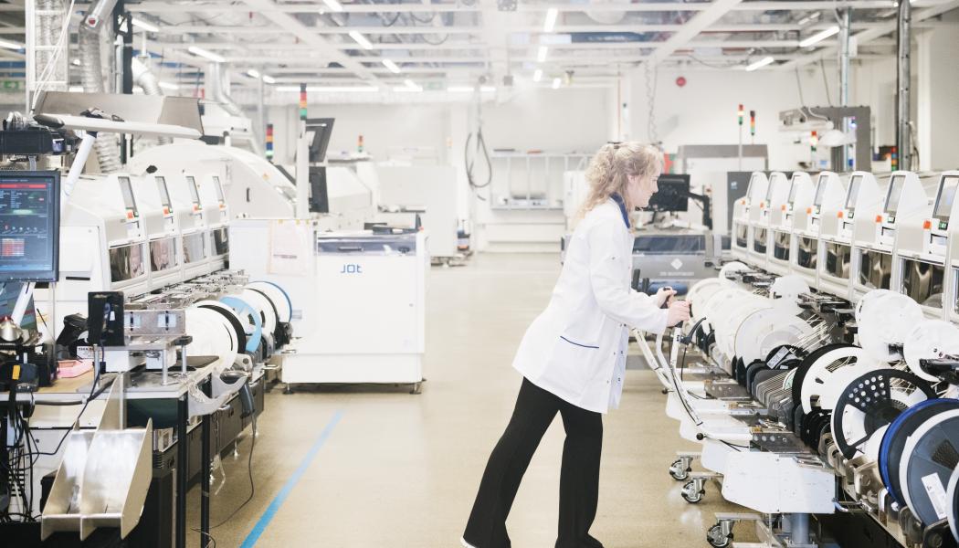 Projektledare arbetar med SMT-maskin i industrilabb. Foto: Bredda bilden