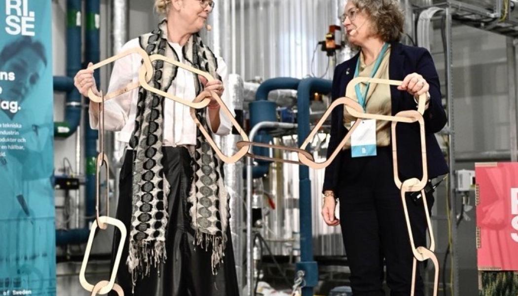Malin Frenning, vd RISE och Anna-Britta Åkerlind, kommunstyrelsens ordförande i Örnsköldsvik kopplar ihop en symbolisk värdekedja vid invigningen av RISE nya pilothall för bioraffinaderi. Foto: RISE