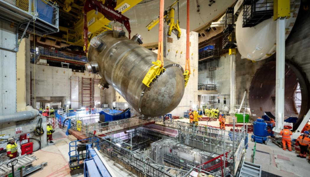 Efter noggranna inspektioner och godkännande från Office for Nuclear Regulation (ONR) lyftes kärlet på plats med hjälp av en intern polarkran. Det sänktes sedan ner i reaktorbyggnaden med endast 40 millimeters marginal på varje sida, en operation som krävde stor precision. Kärlet kommer att flankeras av fyra ånggeneratorer, 25 meter höga, som ska installeras nästa år. Foto: EDF Energy.