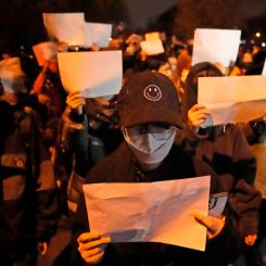 Ng Han Guan/AP/TT: Demonstranter håller upp vita pappersark, som ska symbolisera censur, under en demonstration i Peking på söndagen.