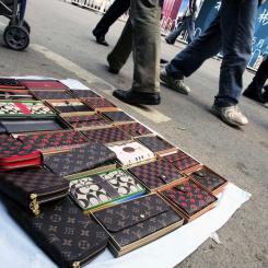 Greg Baker/AP/TT: Plånböcker från "Louis Vuitton" till försäljning på en gata. Arkivbild.