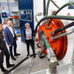 Anna Söderholm, Daniel Kajhager och Karl Lindblom i en av de nyinredda textboxarna, där en stor Hägglunds CBM-motor för tillfället är monterad för tester. Foto: Hägglunds