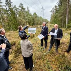 Håvard Kristiansen från Norsk Kjernekraft AS visar upp platsen för vad de hoppas ska bli Haldens nya kärnkraftverk. Här flankeras han av sin chef Jonny Hesthammer och gäster från den kanadensiska kärnkraftsindustrin. Foto: Norsk Kjernekraft AS. Kedit: Jan M. Moberg