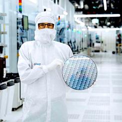 En tekniker i renrummet på Infineon Technologies i Villach, Österrike, håller i ett 300 mm stort galliumnitrid-wafer. Källa: Infineon